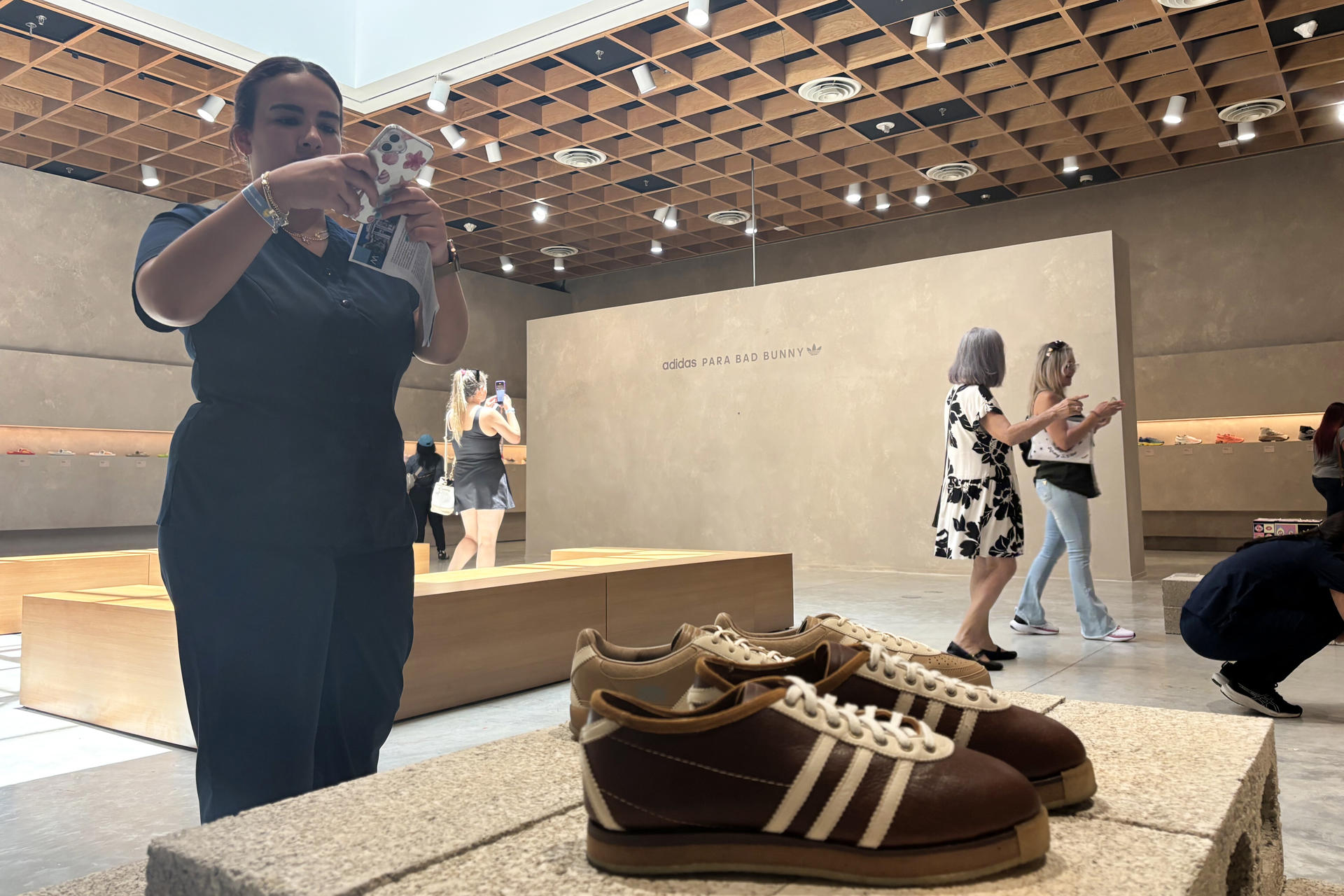 Una persona toma una fotografía a calzados Adidas de Bad Bunny durante la exposición 'The Archive' este viernes, en el Museo de Arte de Puerto Rico (MAPR), en San Juan (Puerto Rico). EFE/ Esther Alaejos
