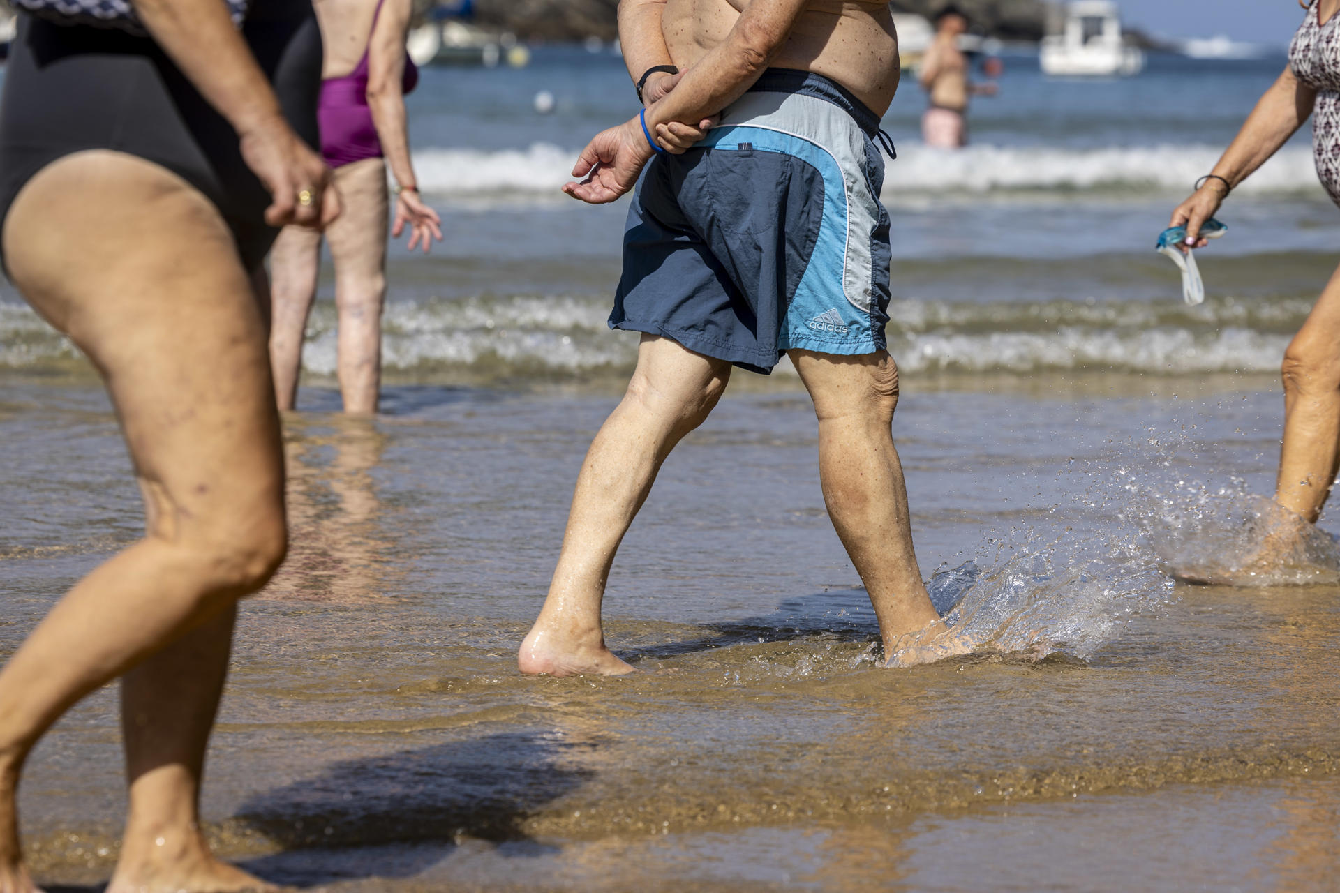 Varias personas pasean por la orilla de la playa de La Concha de San Sebastián este jueves. EFE/Javier Etxezarreta