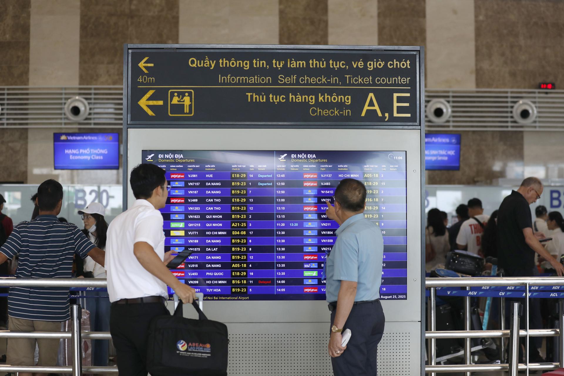 HANOI (Viet Nam), 25/08/2025.- Passengers check flight information at Not Bai airport in Hanoi, Vietnam, 25 August 2025. Domestic airlines have announced the cancellation and adjustment of many flights as Typhoon Kajiki is forecast to make landfall in Vietnam on 25 August. EFE/EPA/LUONG THAI LINH