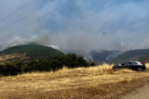 Un helicóptero trabaja en la extinción del incendio en Odollo y Llamas (León) este viernes. EFE/ Ana F. Barredo