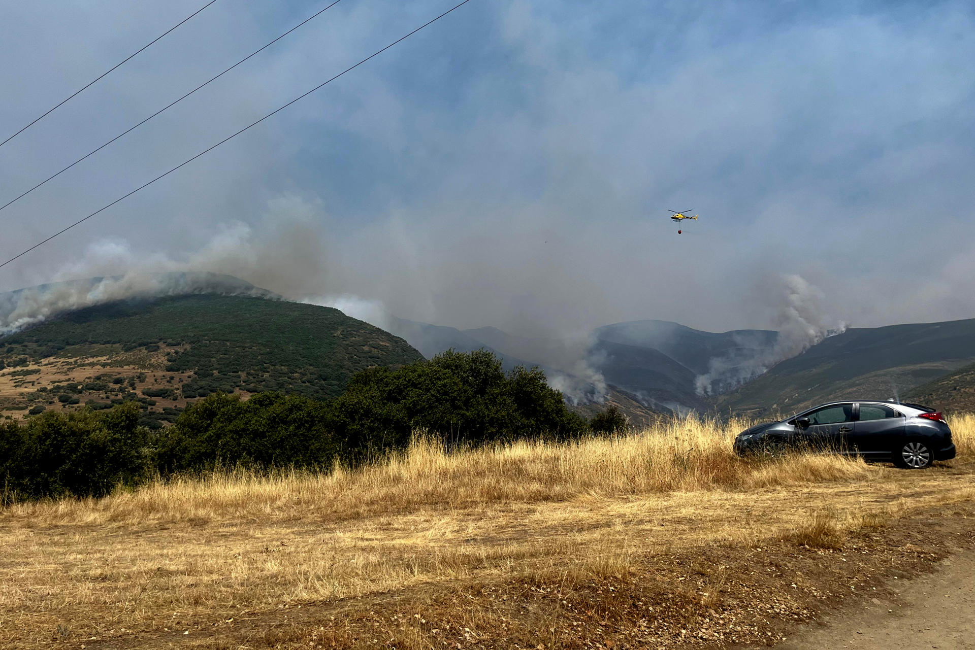 Un helicóptero trabaja en la extinción del incendio en Odollo y Llamas (León) este viernes. EFE/ Ana F. Barredo