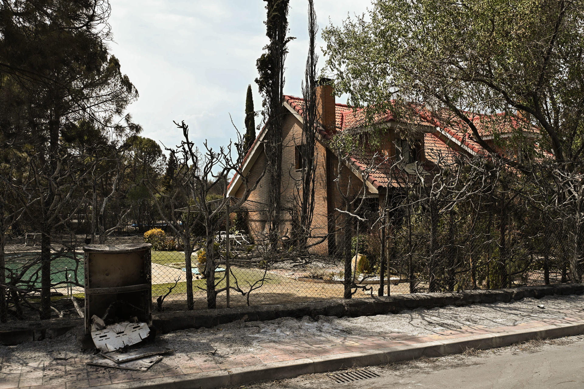 Vista de una casa dañada por el incendio que desde ayer afecta a la localidad de Tres Cantos, Madrid, que ya está perimetrado y evoluciona favorablemente. EFE/Fernando Villar
