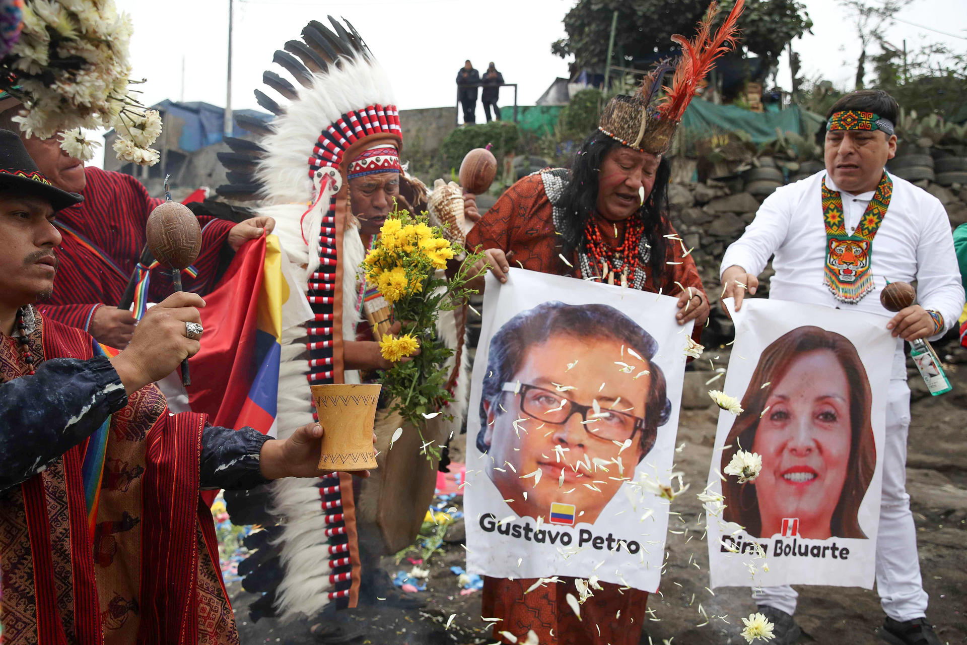 Chamanes peruanos sostienen carteles con la imagen del presidente de Colombia, Gustavo Petro, y la presidenta de Perú, Dina Boluarte, durante una ceremonia este lunes, en el cerro San Cristóbal en Lima (Perú). EFE/ Paolo Aguilar
