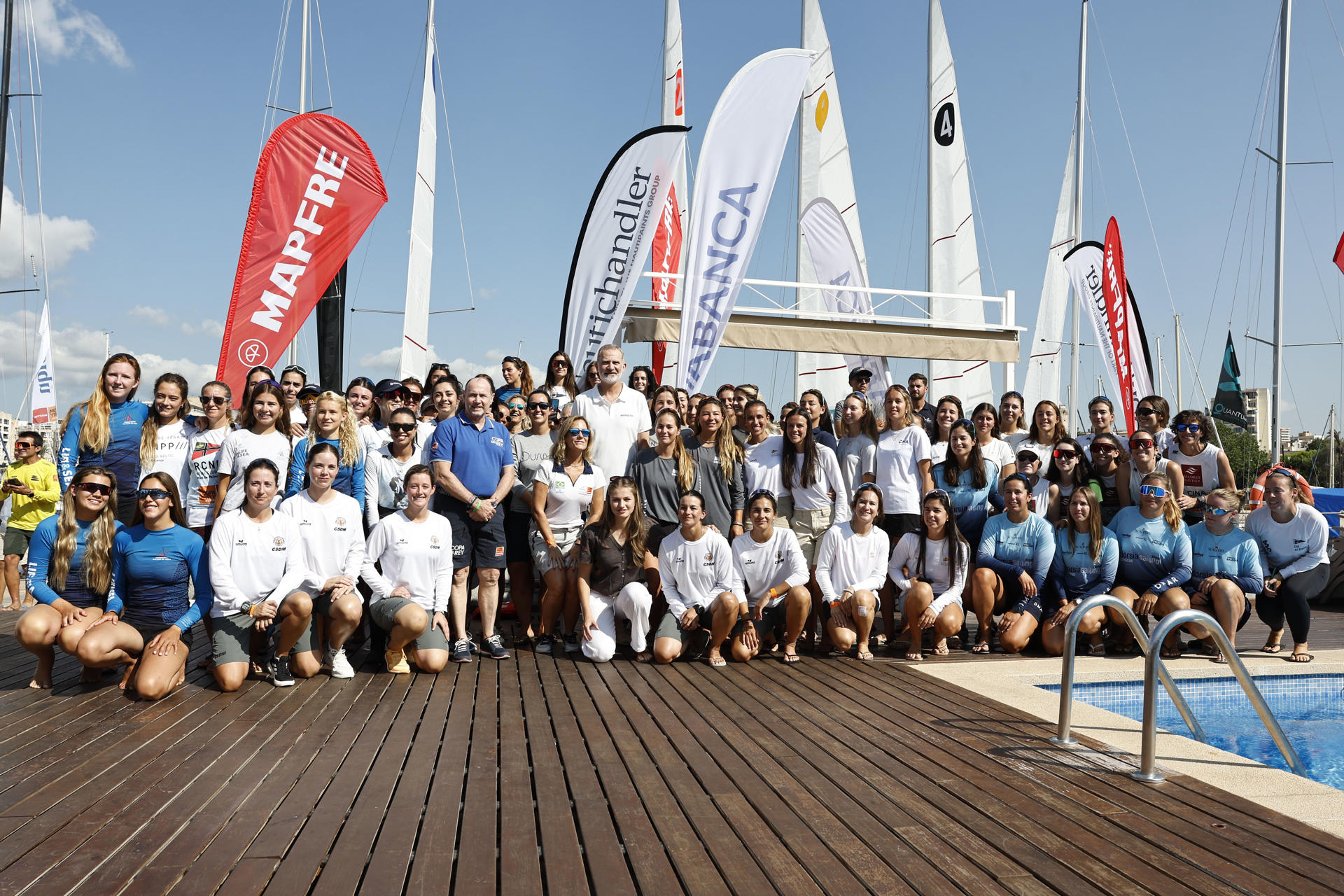 El rey Felipe VI y la princesa Leonor posan para un foto con las participantes de la Women's Cup, a su llegada al Club Náutico de Palma donde se celebra la última etapa de la Copa del Rey Mapfre, este sábado. EFE/Ballesteros
