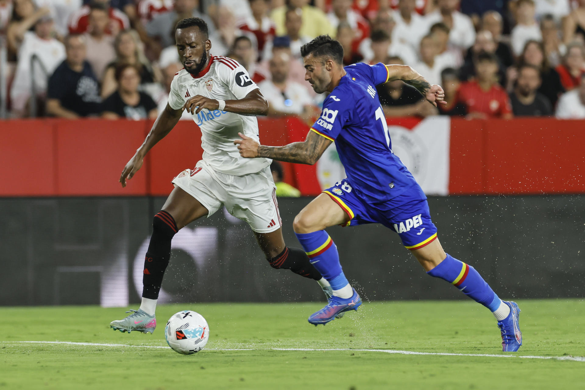 El extremo del Sevilla Dodi Lukébakio (i) ante el defensa del Getafe Rico en el estadio Sánchez Pizjuán de Sevilla. EFE/José Manuel Vidal