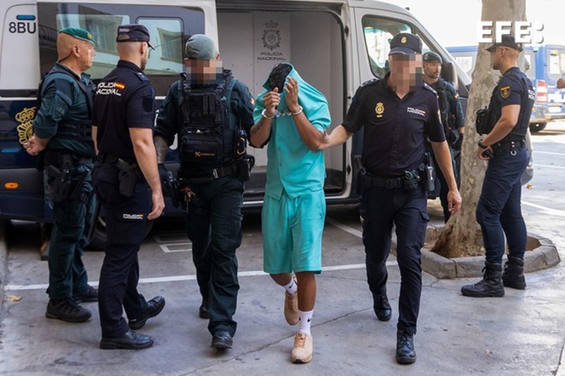 Efectivos policiales escoltan a una de las nueve personas detenidas que han sido puestas a disposición judicial en Palma en el marco de una operación contra el blanqueo de capitales desplegada en Mallorca por parte de la Guardia Civil y la Policía Nacional. EFE/Cati Cladera