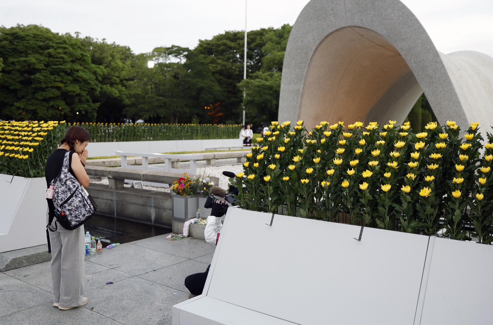 Una mujer reza ante el monumento en memoria de las víctimas de la bomba atómica durante la Ceremonia Conmemorativa de la Paz en el 80.º aniversario del bombardeo atómico de Hiroshima, en el Parque Conmemorativo de la Paz de Hiroshima, Japón, el 6 de agosto de 2025. EFE/EPA/FRANCK ROBICHON