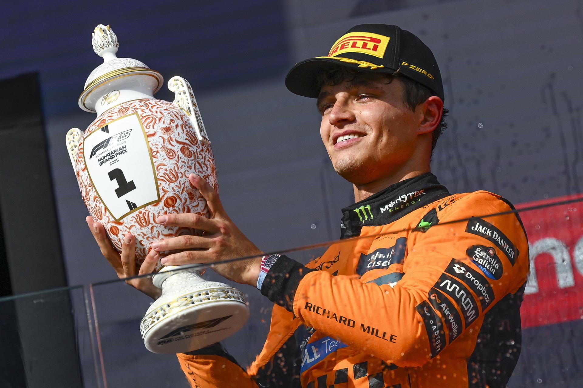 El piloto inglés de McLaren Lando Norris con el trofeo del Gran Premio de Hungría que logró este domingo sobre el trazado de Hungaroring, que le permite acortar la distancia en el Mundial de F1 a nueve puntos respecto al líder y compañero de equipo, Oscar Piastri EFE/EPA/Zsolt Czegledi