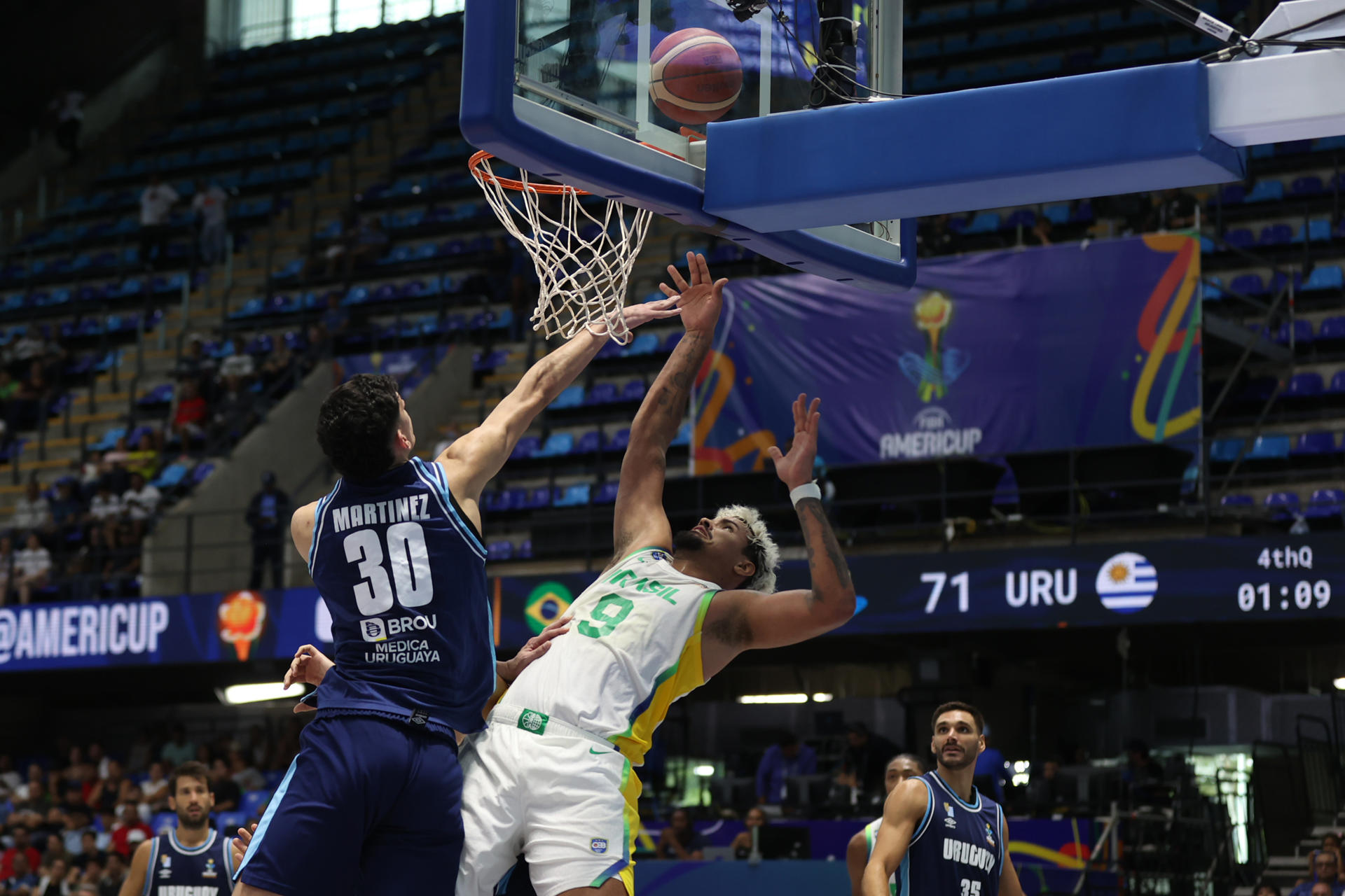 Lucas Dias (c), de Brasil, pugna por el rebote con Nicolás Martínez, de Uruguay, en el partido de la FIBA AmeriCup 2025 disputado en Managua. EFE/ STR