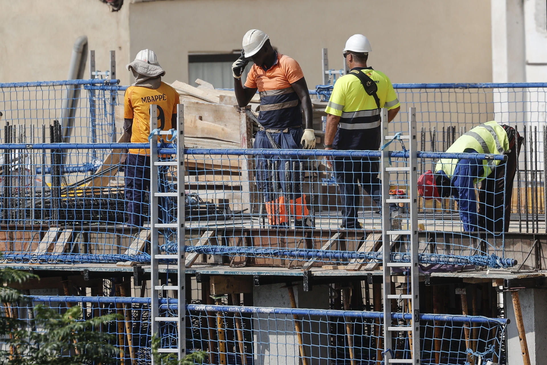 Varios trabajadores, este lunes 18 de agosto, en una obra en el centro de València. EFE/Manuel Bruque