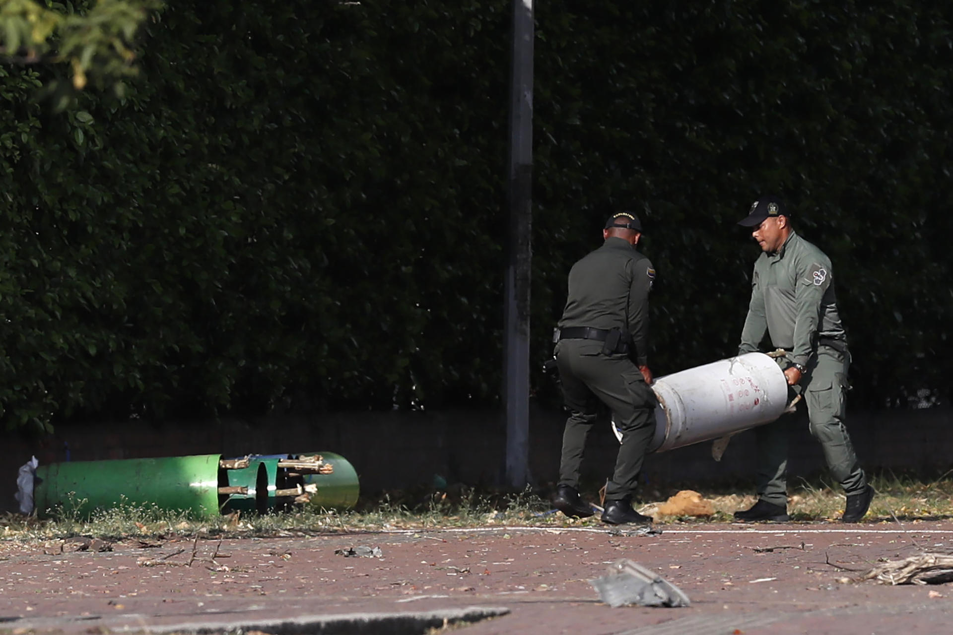 Policías mueven cilindros hallados en la zona del atentado tras una explosión en inmediaciones de la Escuela Militar de Aviación Marco Fidel Suárez este jueves, en Cali (Colombia). EFE/ Ernesto Guzmán Jr
