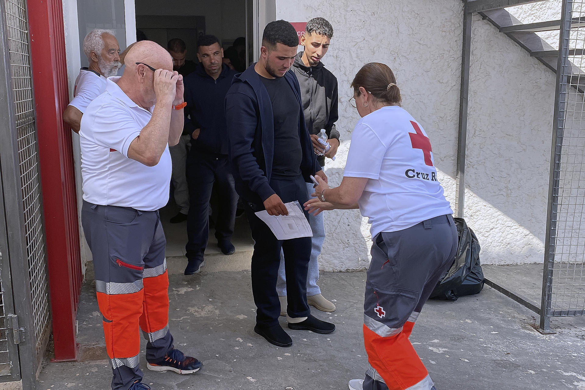 Miembros de Cruz Roja atienden a varios de los nueve inmigrantes de origen marroquí, entre ellos un menor, que habían llegado a la playa del Sotillo en Gualchos- Castell de Ferro (Granada) a bordo de una embarcación de alta potencia en la que viajaban un total de diez personas, y que han sido trasladados al Puerto de Motril (Granada) por la Guardia Civil. EFE/Pedro Feixas