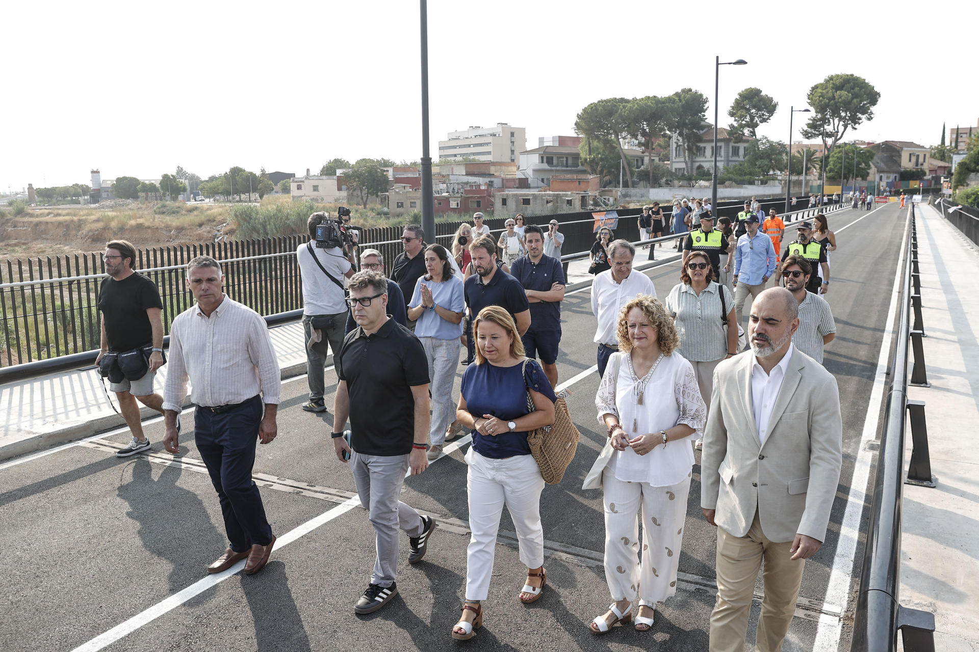 El histórico puente del siglo XIX que une las localidades valencianas de Alaquàs y Torrent a través de la calle Gómez Ferrer reabre al tráfico casi diez meses después de la dana que lo destrozó. En la imagen vecinos y algunas autoridades cruzan el puente. EFE/Manuel Bruque
