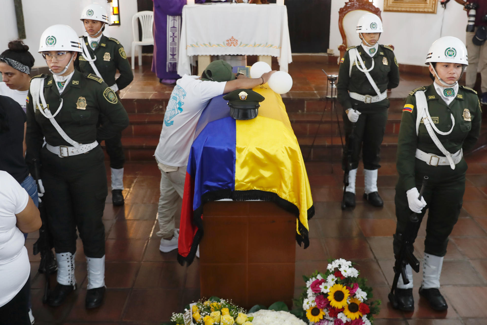 Una persona llora sobre el féretro del patrullero de la Policía de Colombia Michael Stiven Astaiza Ortiz durante sus honras fúnebres este lunes, en Cali (Colombia). EFE/ Ernesto Guzmán