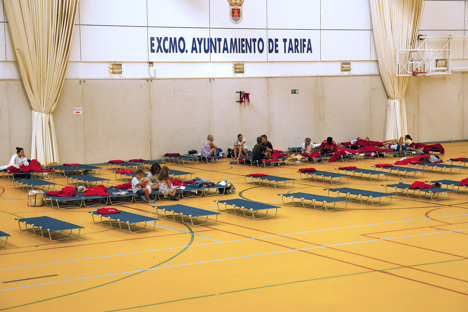 Varias personas han dormido en el polideportivo de Tarifa, después de ayer se produjera un incendio forestal en el paraje de La Peña, en Tarifa (Cádiz), que causó el corte de la N-340 en ambos sentidos cerca de y que provocó el desalojo de instalaciones turísticas. EFE/A.Carrasco Ragel.
