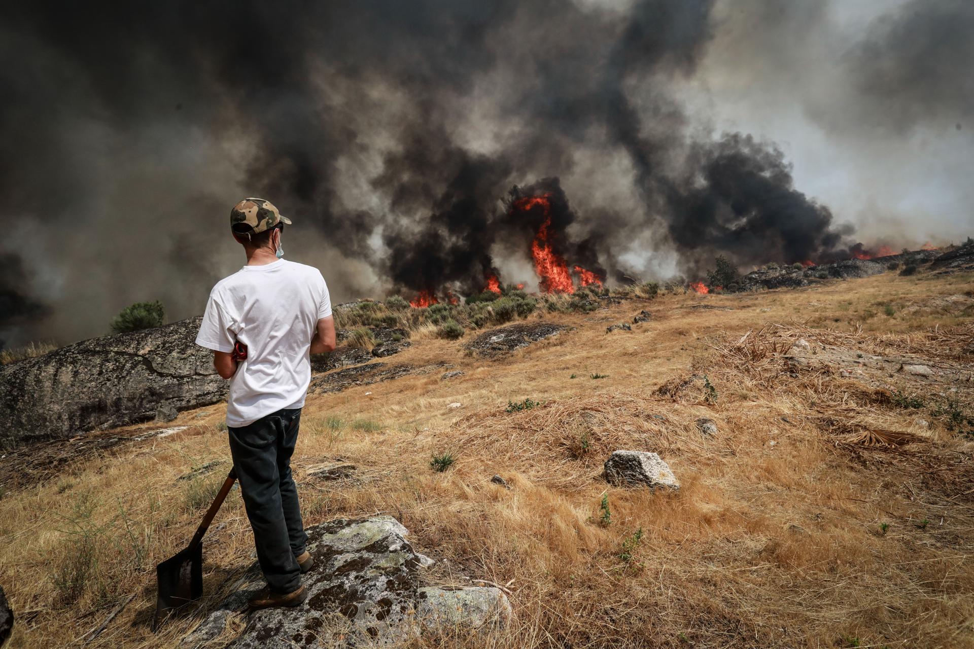 Un hombre observa el incendio forestal en Vila do Touro, Sabugal, Portugal, este sábado 16 de agosto. Los incendios forestales han quemado 139,000 hectáreas en Portugal, la mitad de las cuales en solo dos días, lo que representa 17 veces más que el área quemada en el mismo periodo el año pasado. EFE/EPA/MIGUEL PEREIRA DA SILVA

