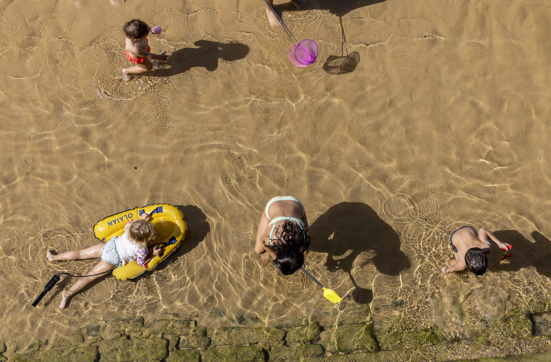 Varios niños juegan en la orilla de la playa de La Concha de San Sebastián este jueves. EFE/Javier Etxezarreta