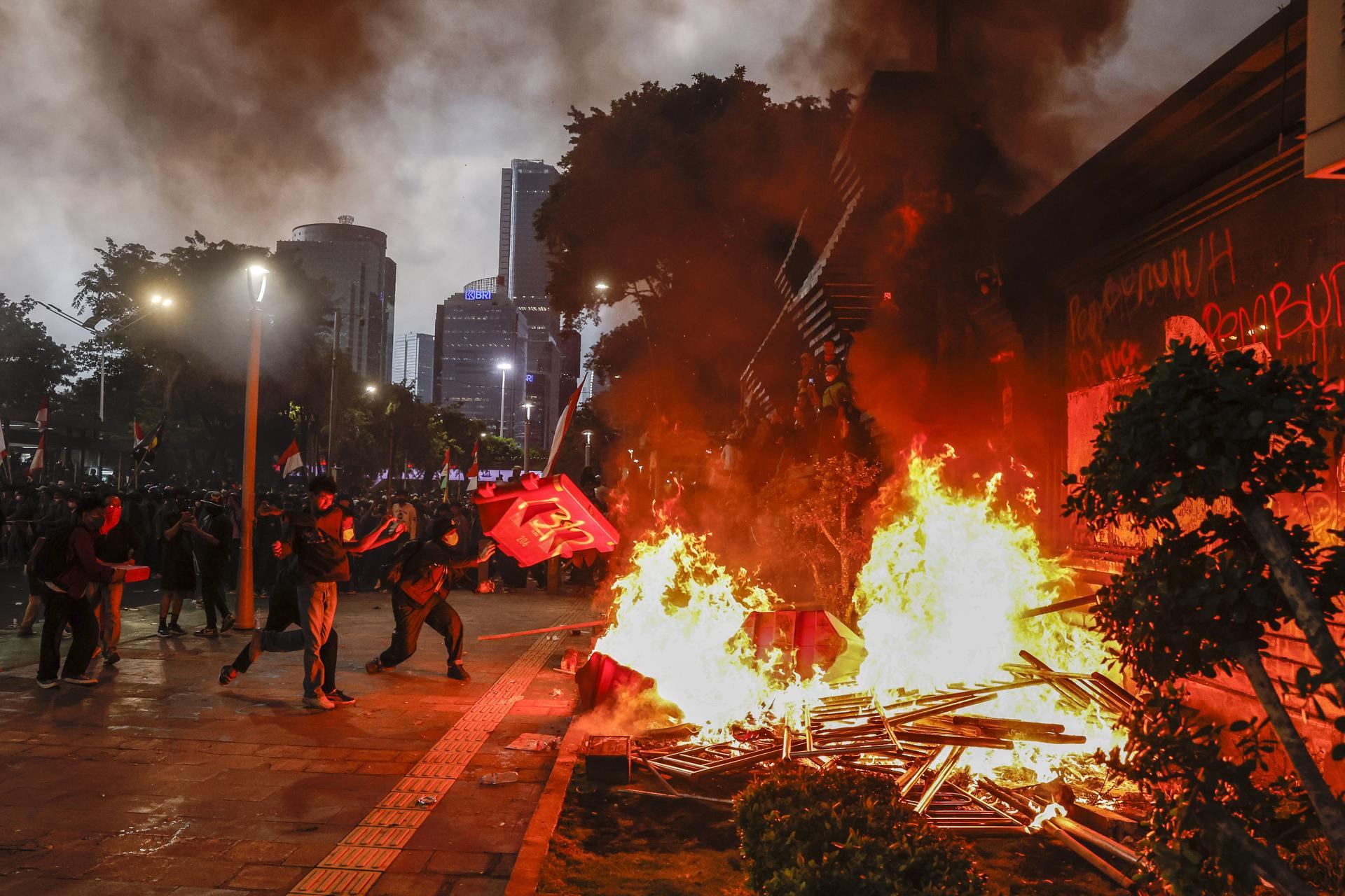 Un grupo de manifestante fue captado este viernes, 29 de agosto, al quemar barreras viales, durante una protesta frente a la sede de la policía de Yakarta, en la capital de Indonesia. EFE/Mast Irham
