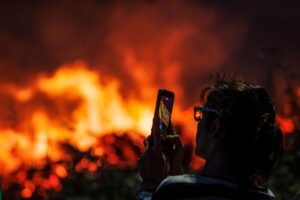 En la imagen de la semana pasada una persona toma una foto del incendio de Chaves, Vila Real, Portugal. EFE/EPA/PEDRO SARMENTO COSTA
