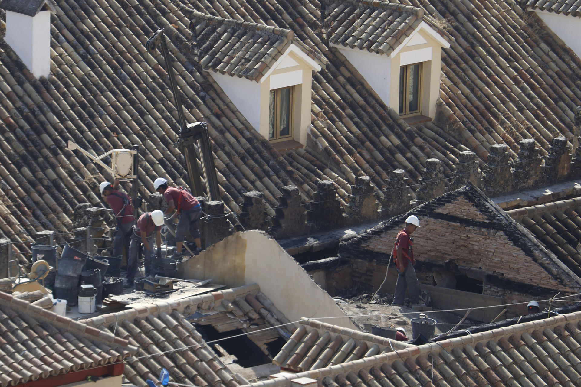 Operarios trabajan en la zona afectada en las cubiertas de la Mezquita-Catedral de Córdoba, sobre todo en el techo de la capilla de la Anunciación, que fue la que colapsó a causa del incendio declarado el pasado viernes en una de las capillas, este lunes en el que la Unidad de Policía Científica de la Policía Nacional junto a los arquitectos y técnicos están inspeccionando los daños sufridos en el monumento. EFE/Salas
