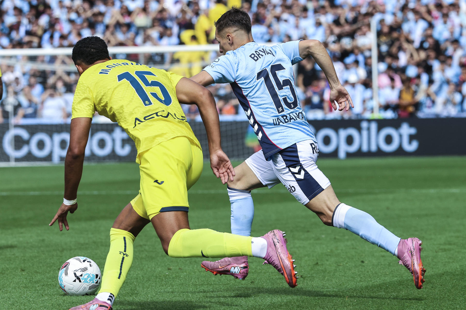 El centrocampista del Celta de Vigo Bryan Zaragoza (d) pugna por un balón con el defensa del Villarreal Santiago Mouriño en el partido de LaLiga disputado este domingo en el estadio Balaidos de Vigo. EFE / Salvador Sas
