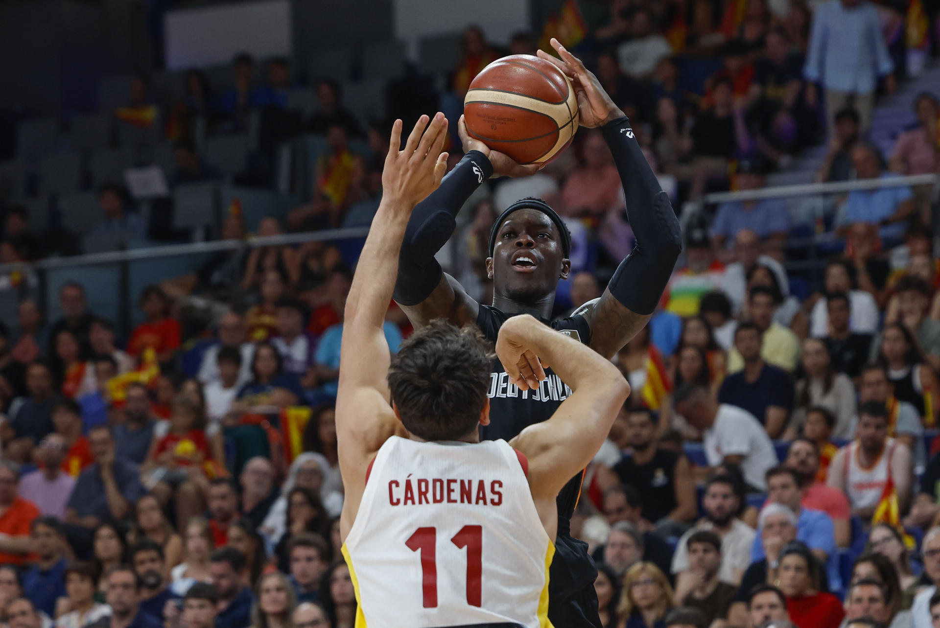 El base de la selección alemana de baloncesto Dennis Schroeder (arriba) se dispone a lanzar ante el español Álvaro Cárdenas, durante el partido amistoso que España y Alemania disputan este jueves en el Madrid Arena. EFE/Mariscal
