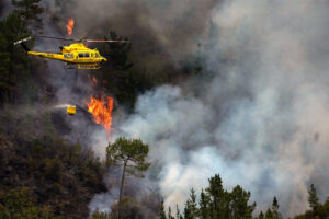 Un helicóptero en labores de extinción del incendio que afecta a los alrededores de San Antolín de Ibias este miércoles. EFE/Paco Paredes