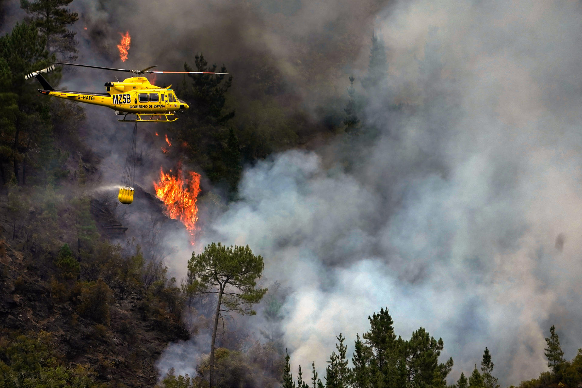 Un helicóptero en labores de extinción del incendio que afecta a los alrededores de San Antolín de Ibias este miércoles. EFE/Paco Paredes