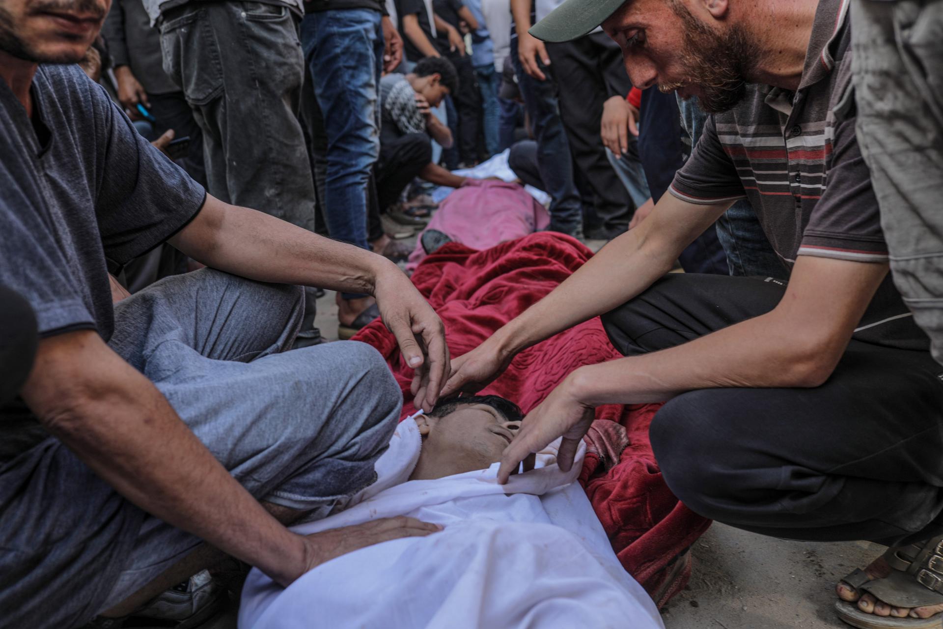 Un grupo de palestinos junto a sus familiares muertos en el hospital Al Shifa de la Franja. EFE/EPA/MOHAMMED SABER