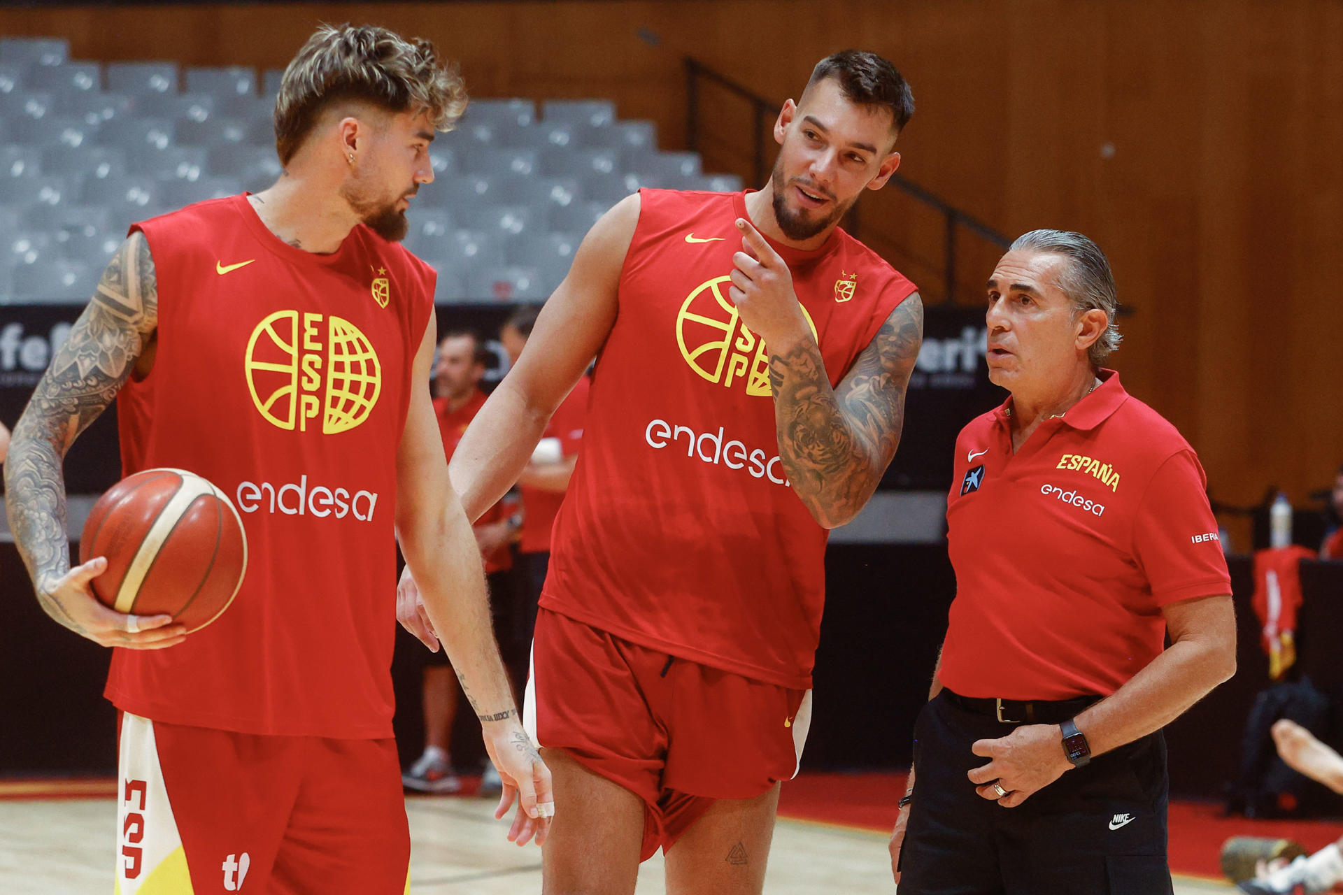 El seleccionador de baloncesto de España, Sergio Scariolo (d), conversa con los internacionales Juancho (i) y Willy Hernangómez (c) durante el entrenamiento de este miércoles en Badalona. EFE/Quique Garcia