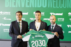 El presidente del Real Betis, Ángel Haro (i), y el director deportivo, Manu Fajardo (d), sujetan la camiseta con el centrocampista colombiano Nelson Deossa, durante su presentación como nuevo jugador bético. EFE/José Manuel Vidal