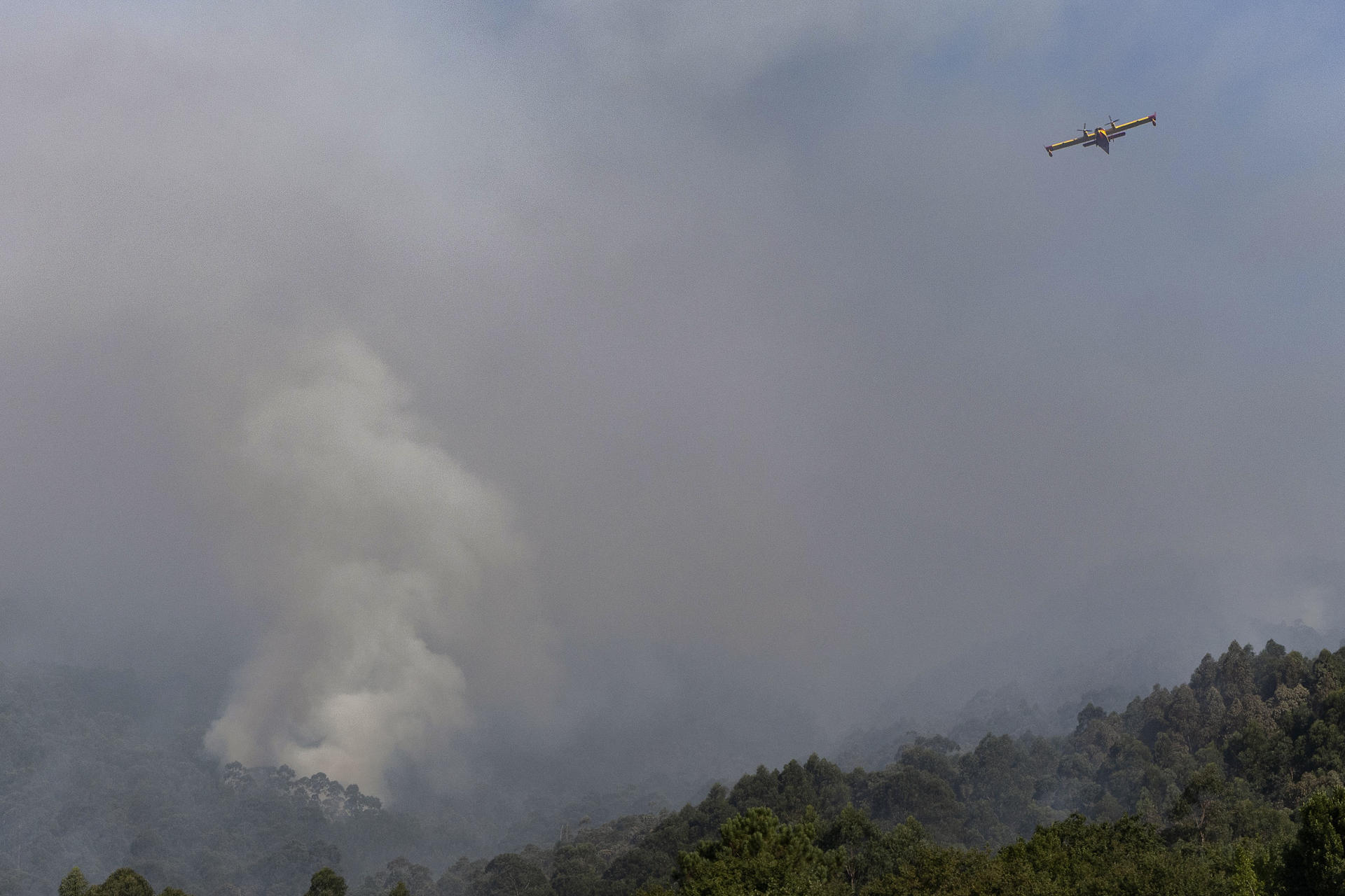 Un hidroavión sobrevuela este viernes el incendio de Vilaboa, con 50 hectáreas ardidas, donde se mantiene la situación 2 por la proximidad al núcleo de Vilar, en Santa Cristina de Cobres.EFE/ Salvador Sas