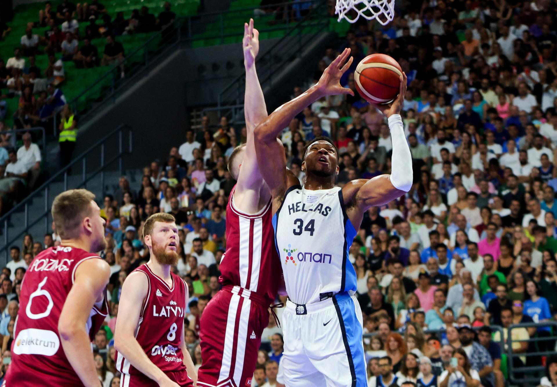 El pívot griego Giannis Antetokounmpo (d) en acción ante el letóns Kristaps Porzingis (I) durante el partido amistoso jugado en Atenas, Grecia. EFE/EPA/GEORGIA PANAGOPOULOU