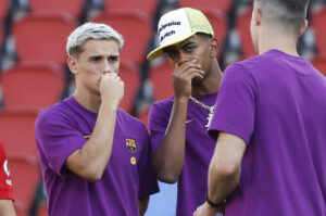 Los jugadores del FC Barcelona, Gavi (i) y Lamine Yamal (c), recorren el terreno de juego este sábado, previo a la primera jornada de LaLiga EA Sports, entre el RCD Mallorca y el FC Barcelona, en el estadio de Son Moix de Palma de Mallorca. EFE/ Cati Cladera