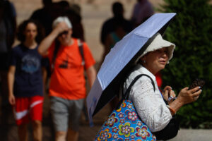 Una mujer se protege del sol con un paraguas en el centro de Córdoba este viernes, una jornada marcada por las altas temperaturas. EFE/Salas