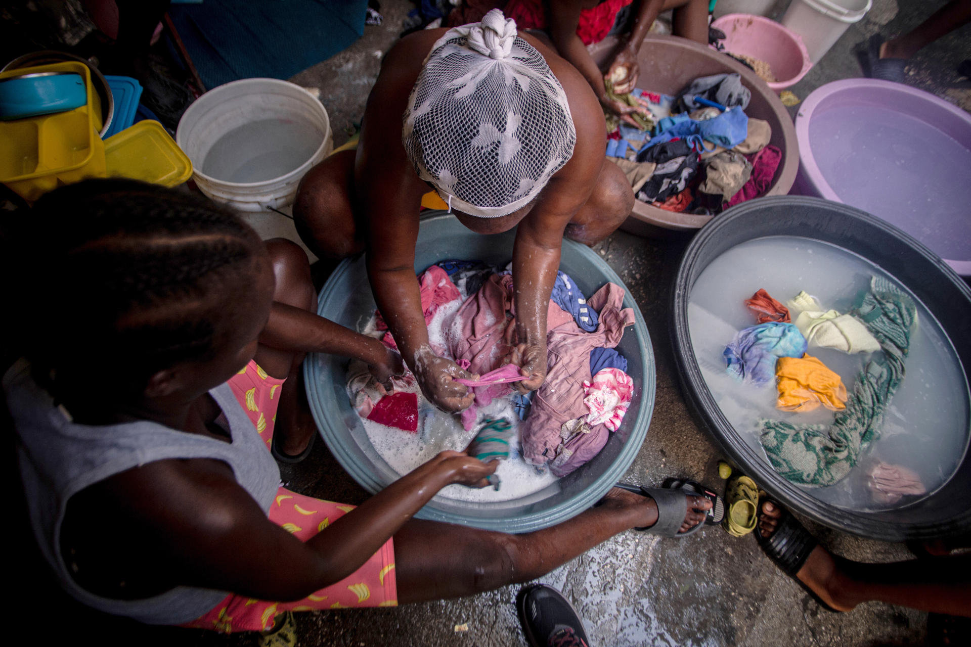 Fotografía de mujeres lavando ropa en el interior de una carpa en un campamento de refugiados, en Puerto Príncipe (Haití). EFE/ Mentor David Lorens