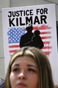 Fotografía de archivo de un cartel que reclama justicia detrás de Jennifer Vásquez Sura, esposa de Kilmar Ábrego García. EFE/EPA/JOHN AMIS