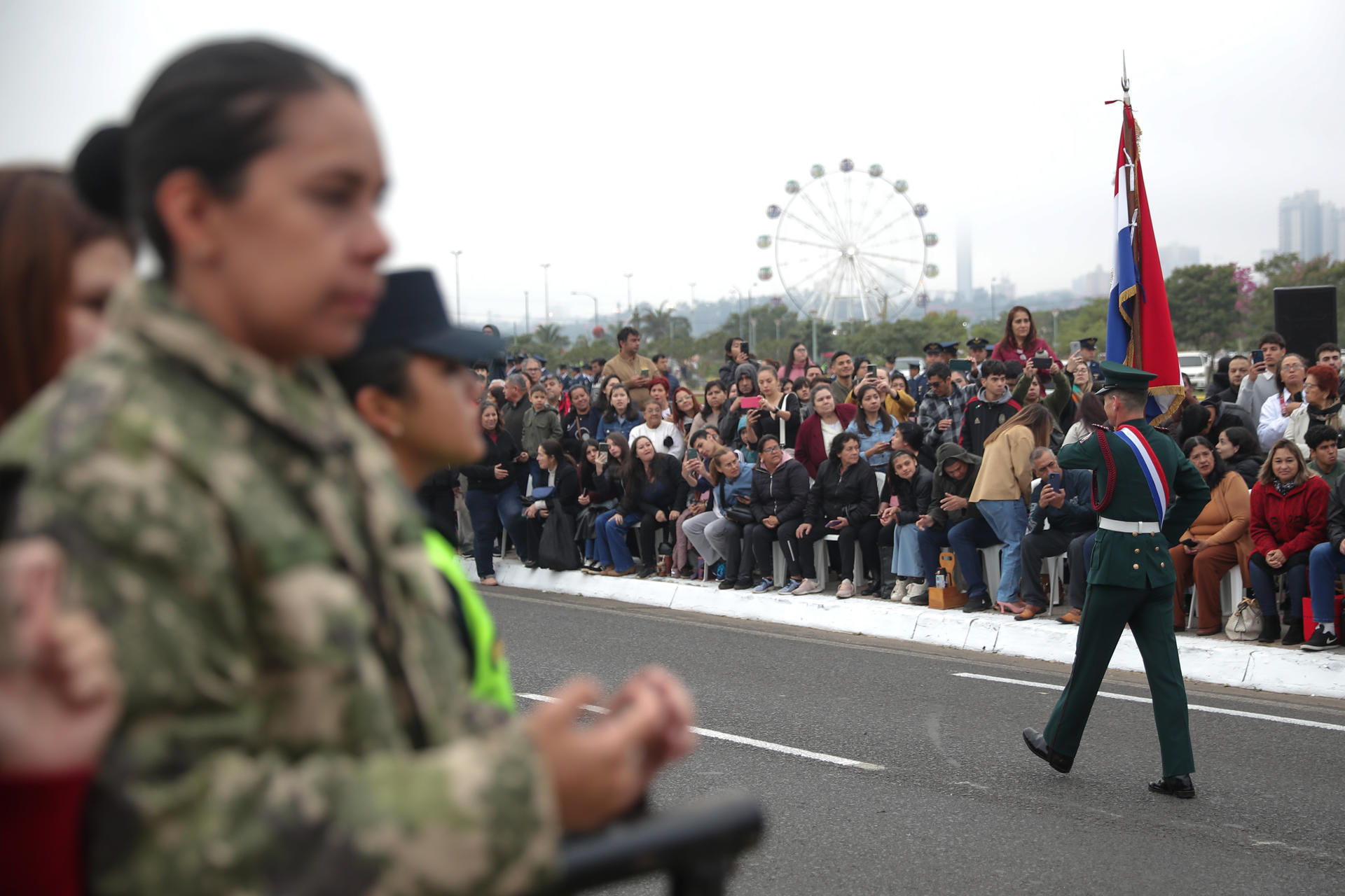 Personas observan el desfile militar por la conmemoración de los 488 años de fundación de Asunción este viernes, en Asunción (Paraguay). EFE/ Juan Pablo Pino