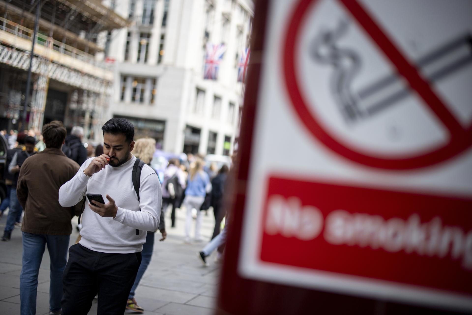 Fotografía de archivo, tomada el 30/05/2023, que muestra a un hombre caminando por una calle de Londres mientras usa un vape. EFE/EPA/TOLGA AKMEN