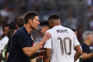 El entrenador del Real Madrid, Xabi Alonso (izquierda), habla con el jugador Kylian Mbappé durante un partido amistoso entre el WSG Tirol y el Real Madrid, en Innsbruck, Austria, el 12 de agosto de 2025. (Futbol, Amistoso) EFE/EPA/ANNA SZILAGYI