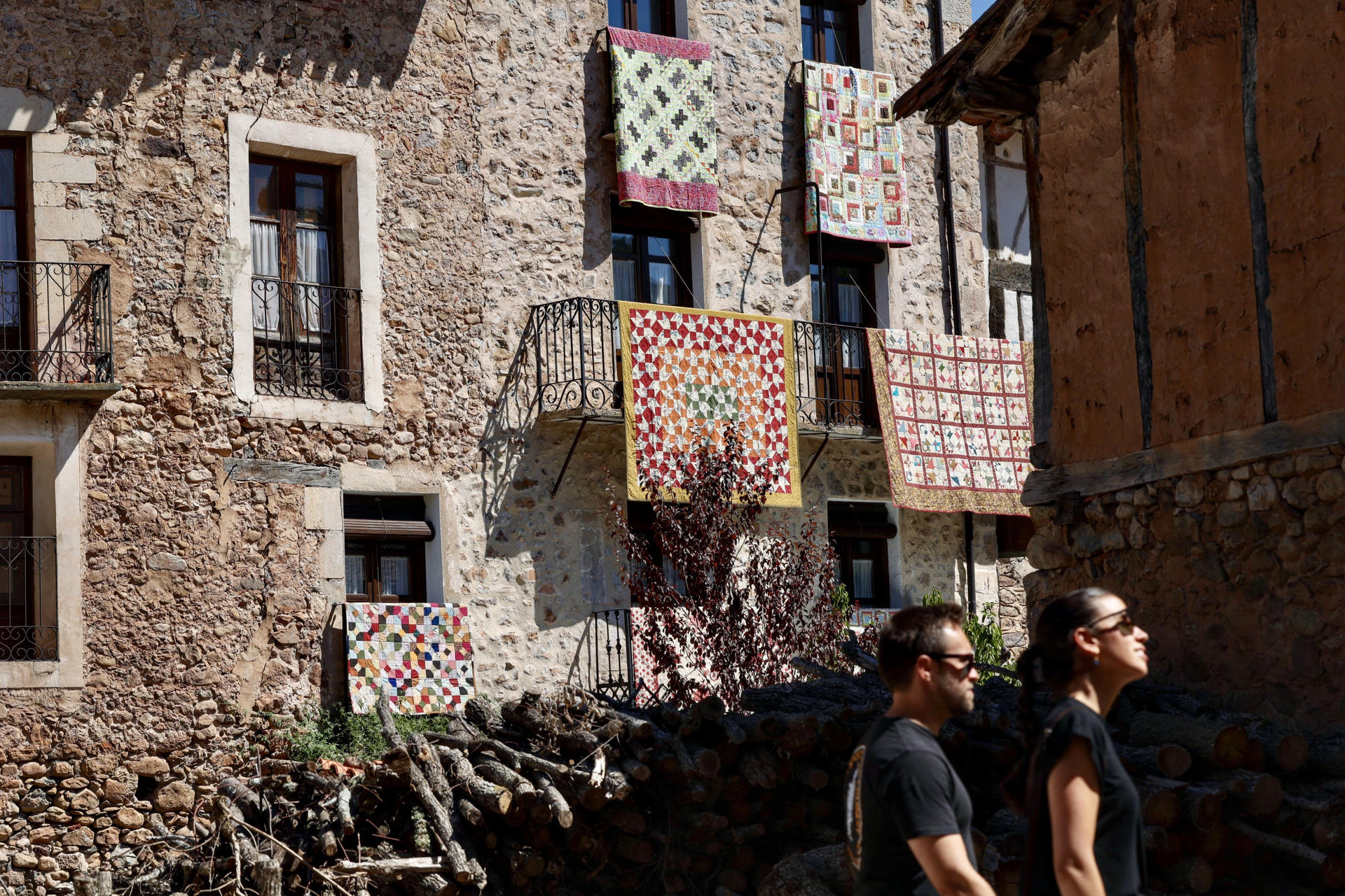 Los balcones y calles de la localidad riojana de Pradillo de Cameros se han engalanado este sábado con decenas de coloridas creaciones textiles en la 'Fiesta de las almazuelas colgadas', organizada para mostrar una tradición popular nacida de la necesidad, pero que no ha pasado de moda como afición. EFE/Raquel Manzanares