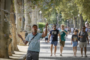 Un hombre hace pompas de jabón para los turistas este lunes de Sevilla, al inicio de la segunda ola de calor de este verano con temperaturas que superan los 40 grados. La persistencia de una masa de aire cálido procedente del norte de África, combinada con un bloqueo anticiclónico sobre la península, agravará la sensación térmica durante toda la semana. EFE /Jose Manuel Vidal