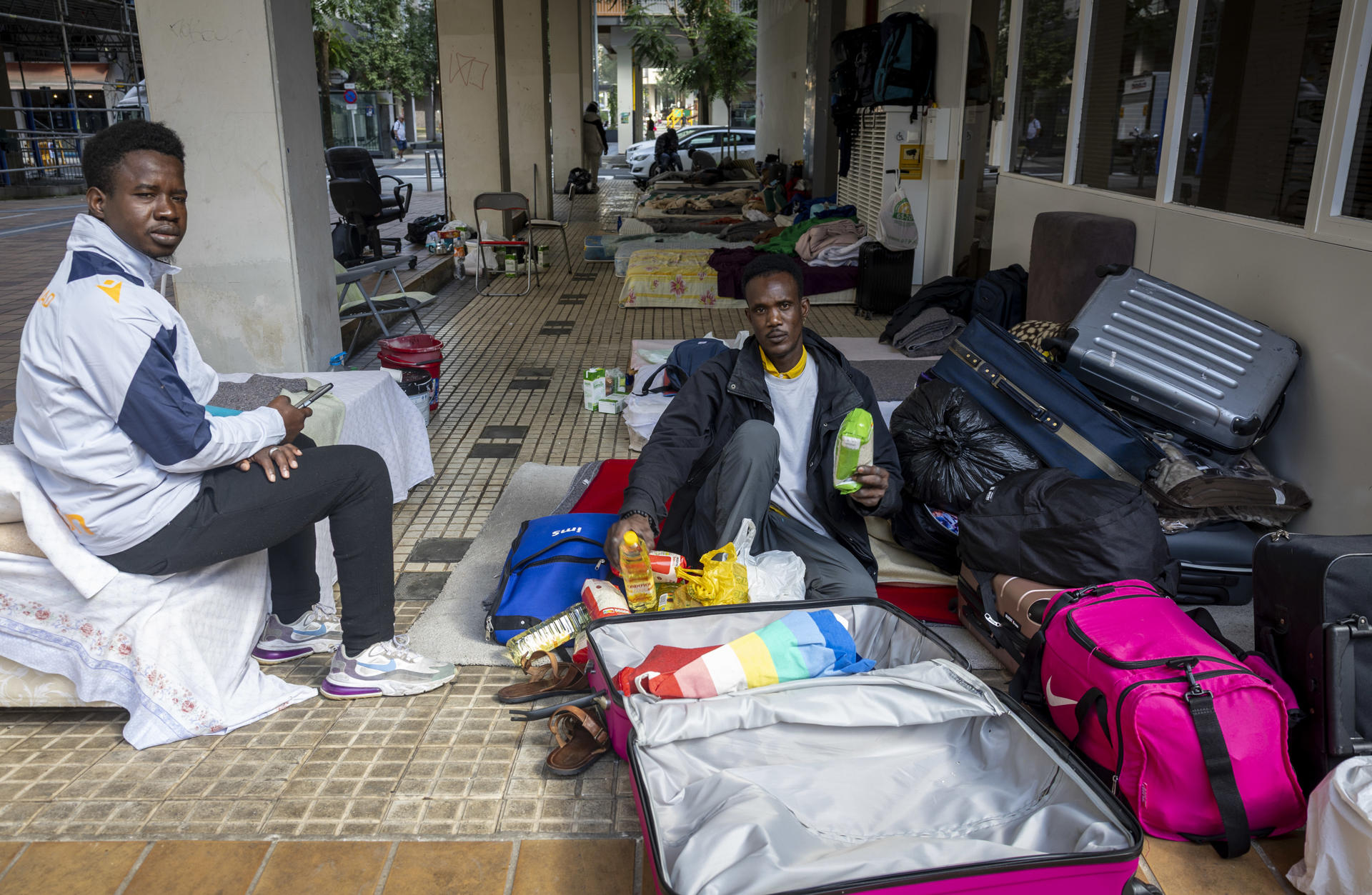 Los migrantes, en su mayoría de Mali, que viven en la calle en el barrio donostiarra de Amara Berri desde hace semanas esperan en su campamento improvisado. La Diputación y el Ayuntamiento de San Sebastián va a alojar en un recurso de la localidad de Oñati (Gipuzkoa), "de manera excepcional" y "ante la falta de respuesta por parte del Gobierno español".EFE/Javier Etxezarreta