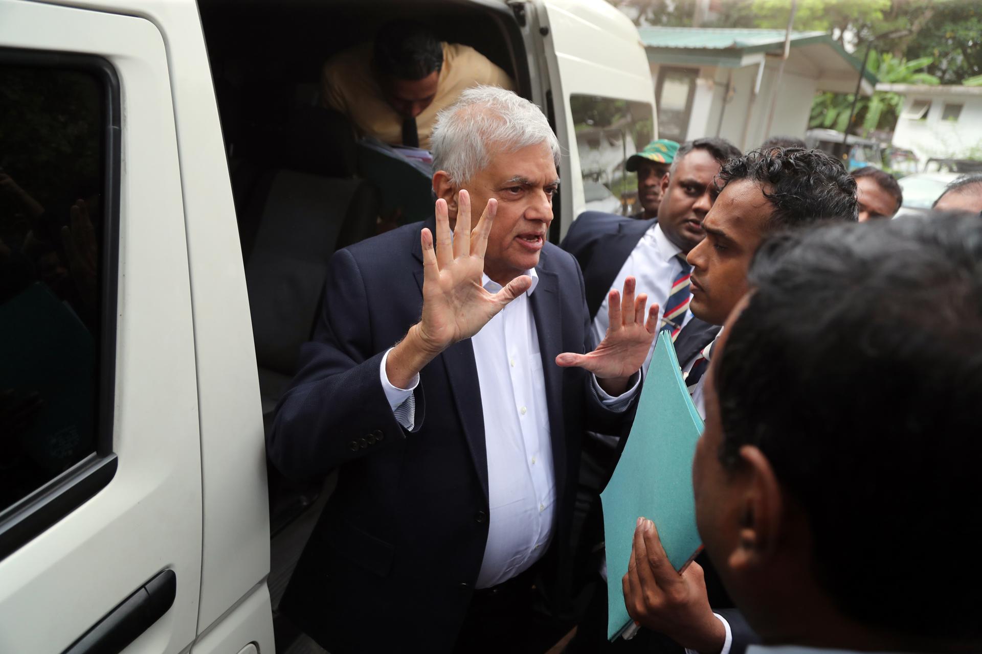 Oficiales del Departamento de Investigación Criminal de Sri Lanka escoltan al ex presidente de Sri Lanka, Ranil Wickremesinghe (C), al tribunal de magistrados en Colombo, Sri Lanka, el 22 de agosto de 2025.EFE/EPA/STRINGER