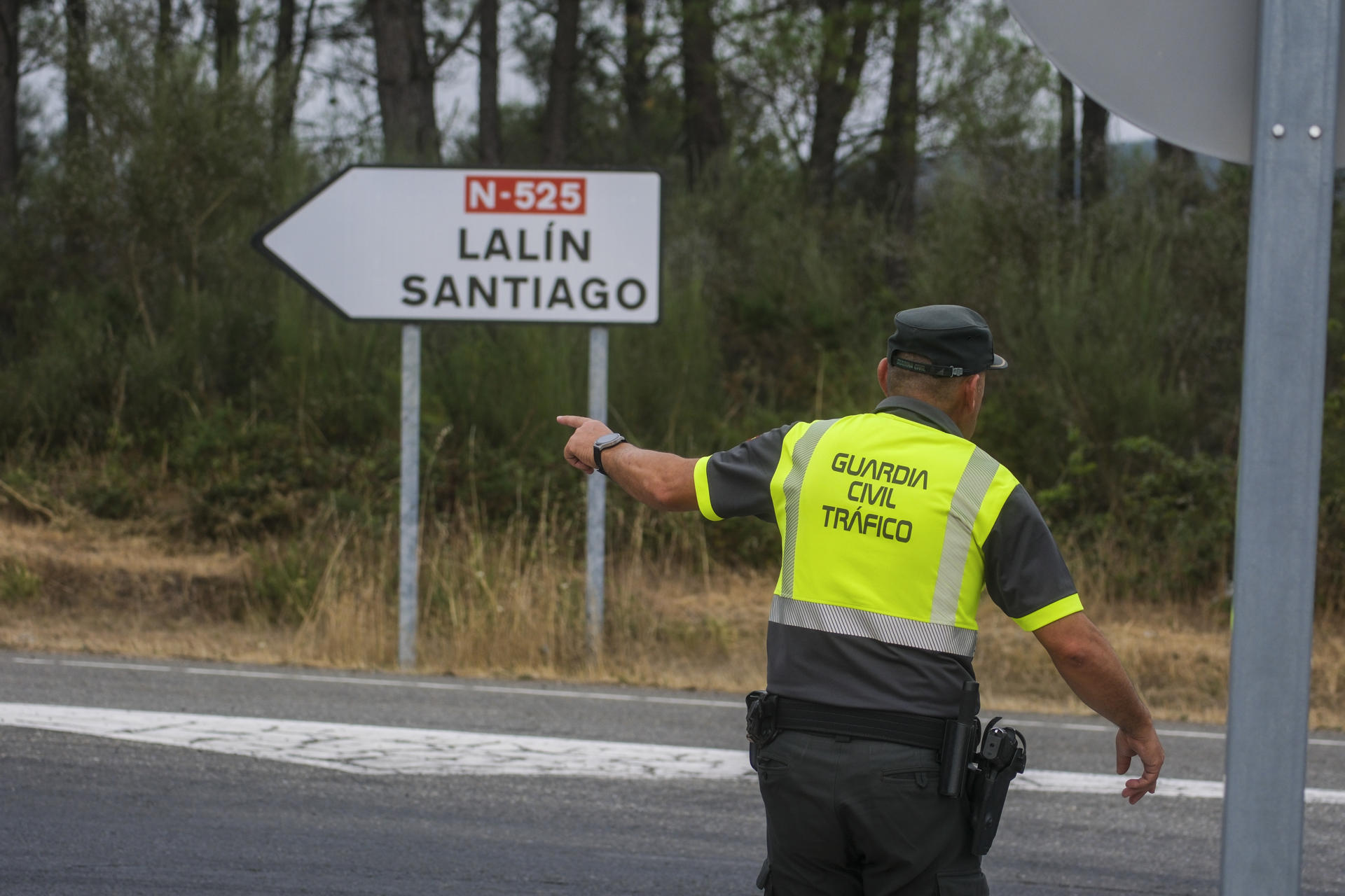 Un agente de la Guardia Civil dirige el tráfico durante el incendio declarado en Dozón (Pontevedra). EFE/Xurxo Martínez