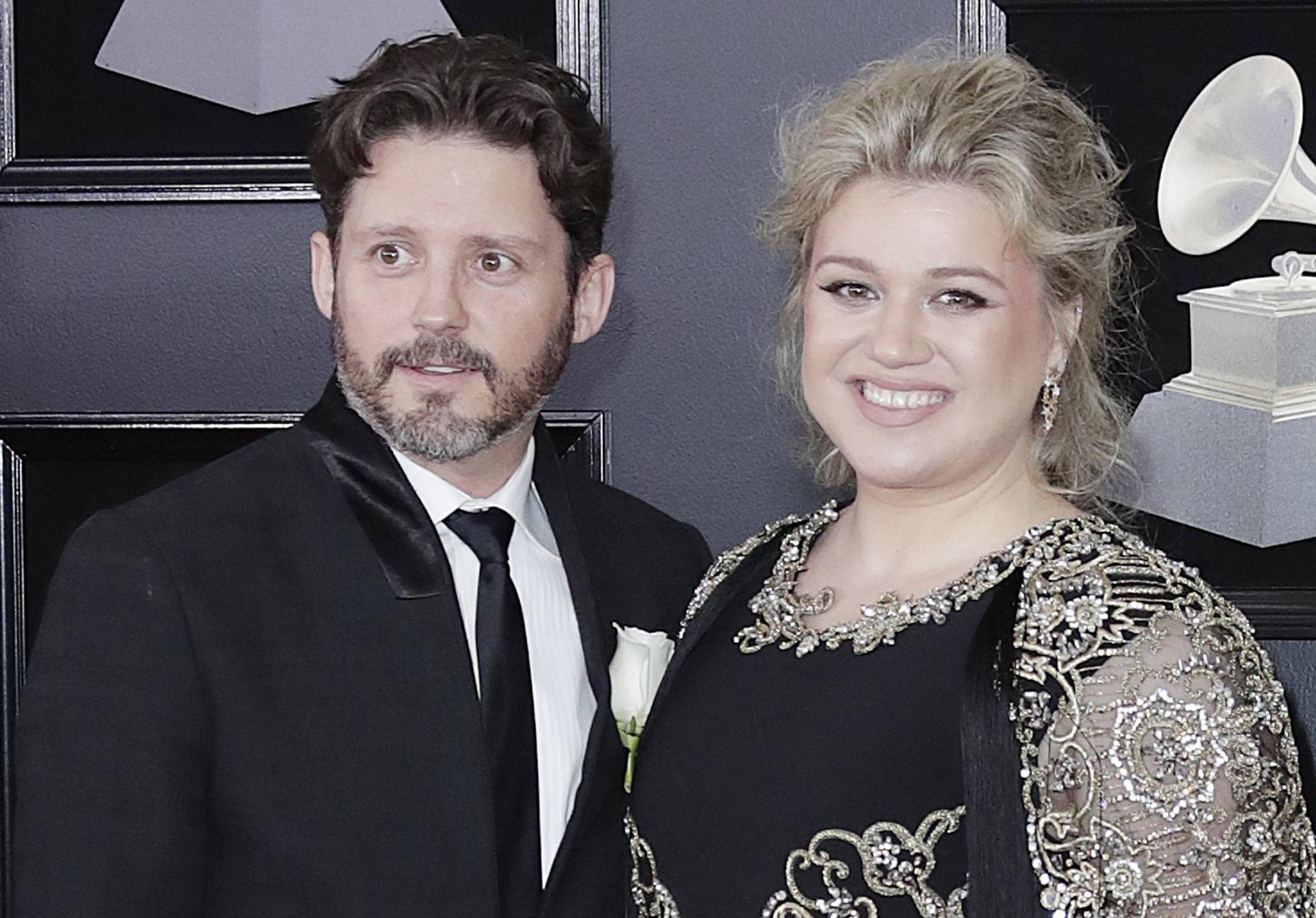 Fotografía de archivo, tomada en enero de 2018, en la que aparecen la cantante estadounidense Kelly Clarkson(d), junto a su marido -en ese entonces-, Brandon Blackstock (i), a su llegada a los Grammy de ese año, en el coliseo Madison Square Garden, en Nueva York (NY, EE.UU.). EFE/Jason Szenes