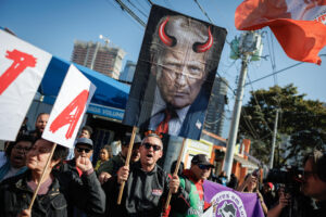 Una persona sostiene un cartel con la imagen del presidente de Estados Unidos, Donald Trump, durante una manifestación contra los aranceles estadounidenses este 1 de agosto de 2025, frente al Consulado General de Estados Unidos en São Paulo (Brasil). EFE/ Isaac Fontana