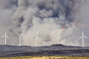 Un helicóptero trabaja este viernes, en labores de extinción del incendio en las proximidades de Urraca-Miguel, barrio anexionado de Ávila capital, y cuyos vecinos han sido evacuados pasadas las 16 horas por la proximidad de las llamas. EFE/ Raúl Sanchidrián