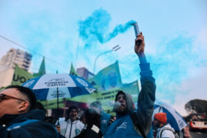 Un hombre sostiene una bengala durante una marcha en el Día de San Cayetano este jueves, en el barrio Liniers en Buenos Aires (Argentina). EFE/ Juan Ignacio Roncoroni