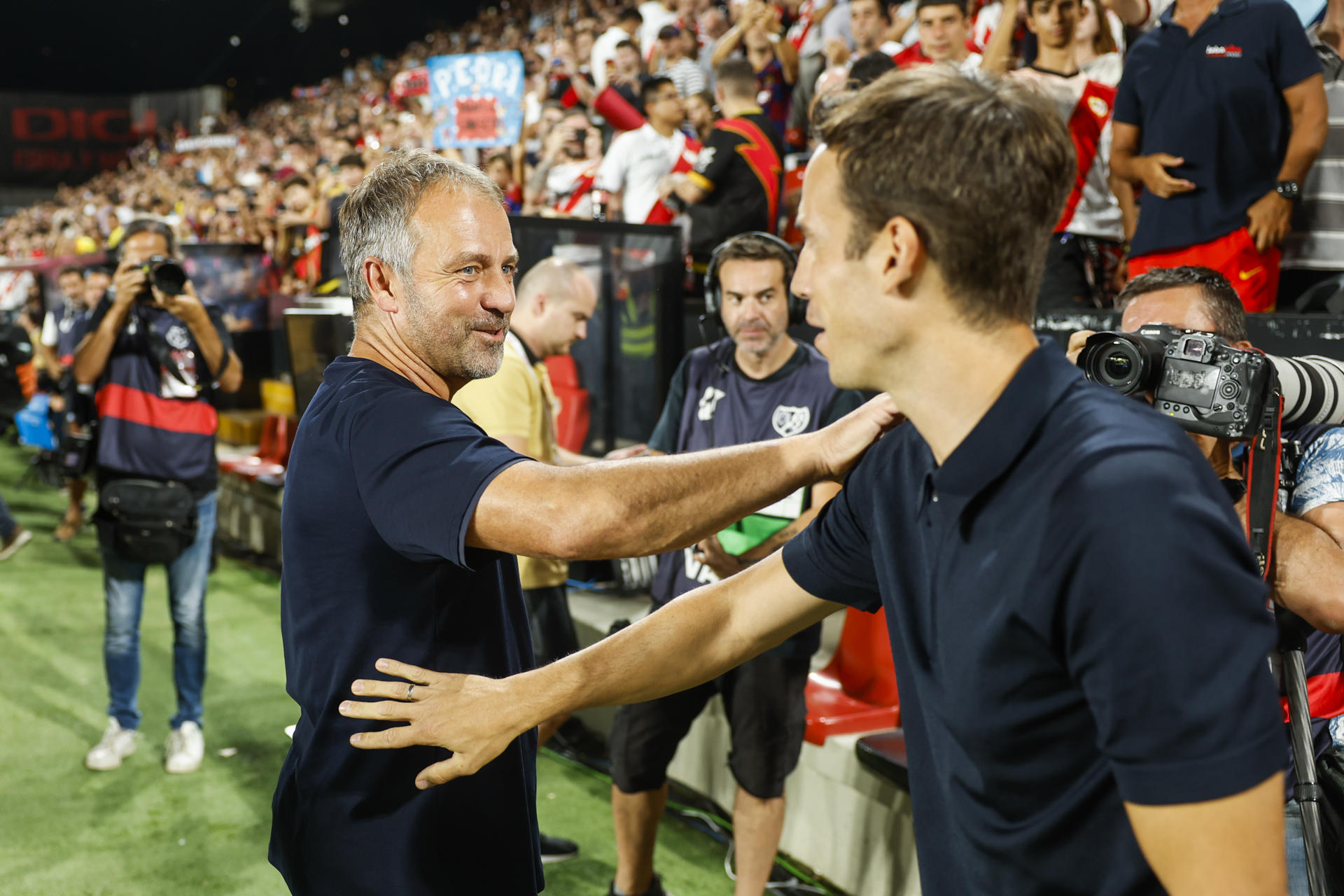 El entrenador del Barcelona, el alemán Hansi Flick (i) saluda al del Rayo, Íñigo Pérez, momentos antes del partido de Liga que disputaron ambos equipos en el estadio de Vallecas, el 27 de agosto de 2024. EFE/Mariscal
